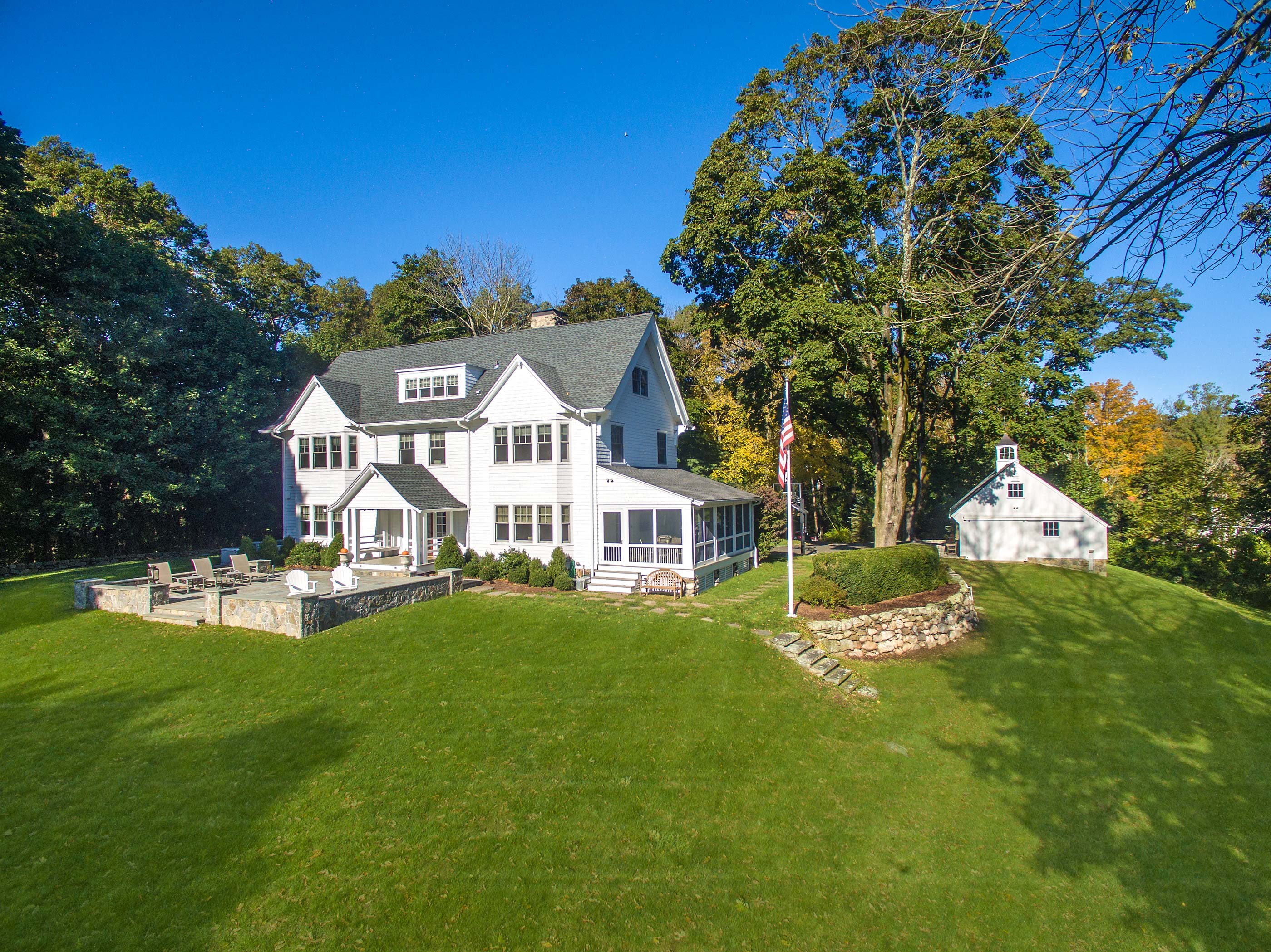 Wide view of a remodeled white residence with prominent rooflines